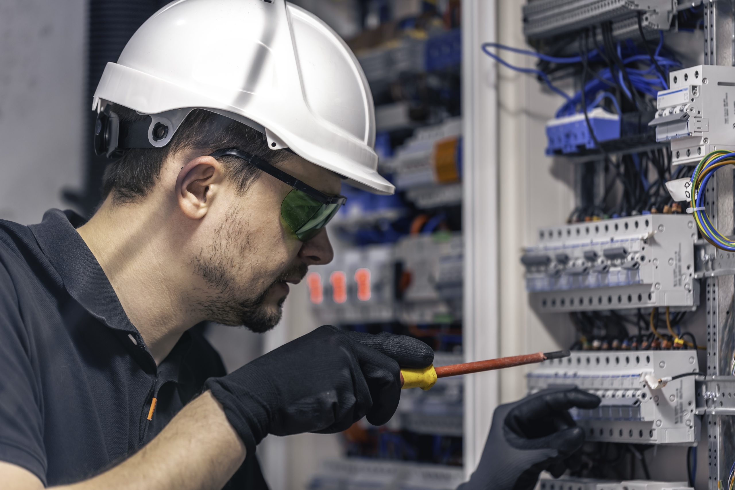 A male electrician works in a switchboard using an electrical connection cable, connecting equipment with tools. SSUCv3H4sIAAAAAAAACpySSW7DMAxF9wFyB0PrGHAsT+lVgi6oITFRRQokOUUR5O7VYAfqtjvzkfzkN/Xc76qKMHDIyUf1jFGIUanFeQsejQ64OazcSi2kLcnD0qEpAWAZSYHeWARVQgaezxpuMkC9KBXxKyWJ8+AXJ13cZUUcvLwGjQzfEnnhc46rLZGSoSOkCDkUzC0ssQ1l8X915o/Pt+Gr1PwnLVwYsVJJyEbOuZR8fXtpb6U1WASawtXDcFCxgBZKgHew8KfvbpGjvhbE+DndZVPiZtHexq3eZogy5g5Mxb9+CWPkxmdwLpSLjRezeXgF5lbM0cYnT6sqEeE4MTxS2ndTS9tmHIauObXDWpAPOmPQSetsQiHmXyhKVxg3IKwfT/2pG+sJONRdP9KajQ2t+yNME7uIrg3vbb97/QIAAP//AwBpAj02uQIAAA==